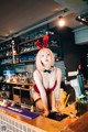 A woman in a bunny costume standing at a bar.