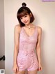 A woman in a pink romper posing for a picture.