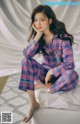 A woman sitting on top of a bed wearing pajamas.