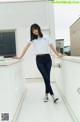 A woman standing on top of a white building.