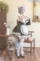 A woman dressed in a maid outfit posing for a picture.