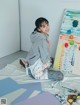 A woman sitting on the floor in front of a painting.