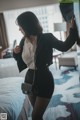 A woman standing in front of a mirror in a hotel room.