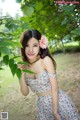 A woman in a floral dress posing for a picture.