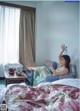 A woman sitting on a bed with her feet up in the air.