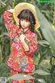 A woman in a red dress and a straw hat posing for a picture.