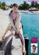 A woman in a bikini sitting on a pier by the water.