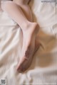 A woman laying on top of a bed with her feet up.