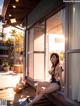 A woman sitting on a window sill in a bikini.