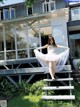 A woman in a white dress is standing on some steps.